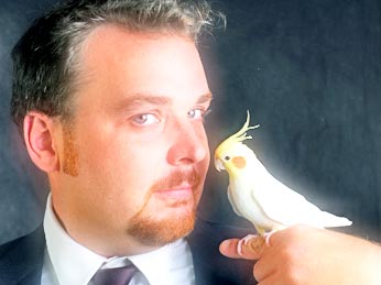 men holds a parrot on his finger